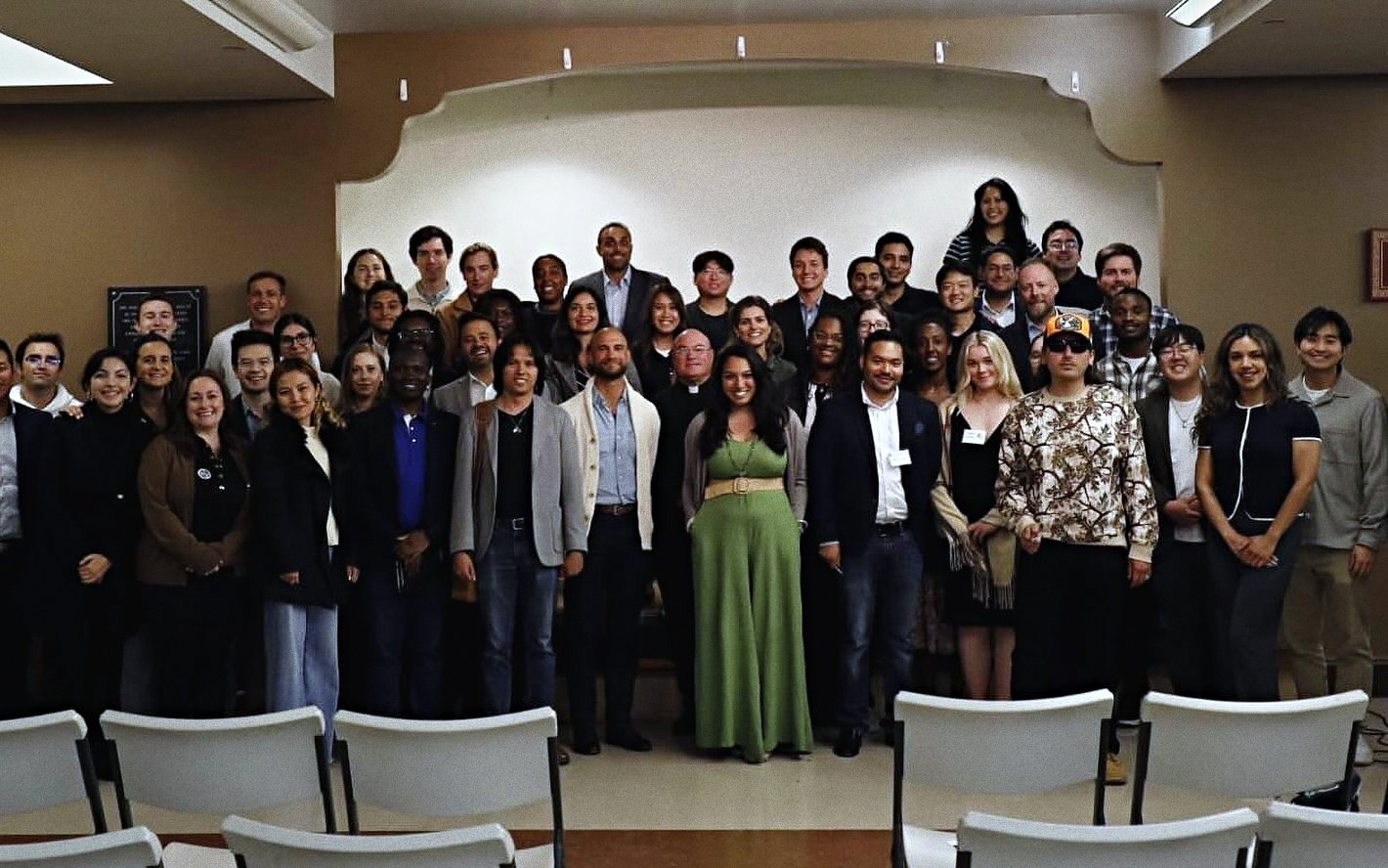 A Catholic Leaders in Action evening in a San Francisco parish hall: the room standing together at the front, rows of chairs behind them.