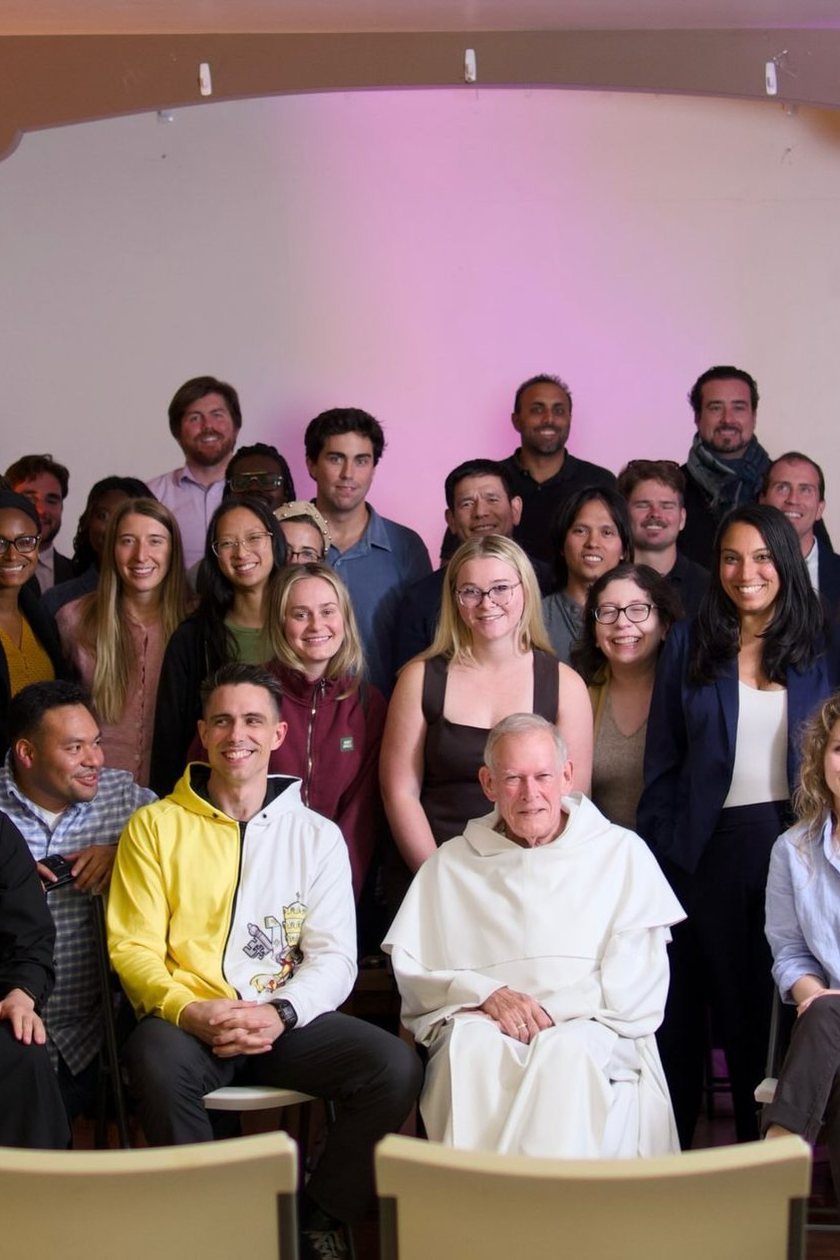 About fifty attendees packed under the arched parish-hall alcove on September 1, a Dominican friar in a white habit seated at the centre.